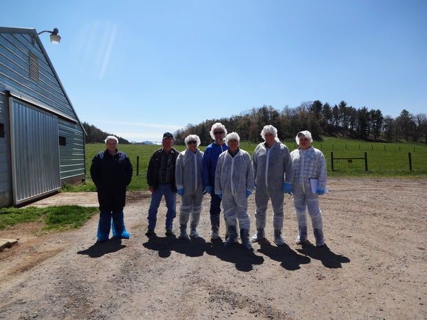 SWET team members in front of poultry house